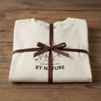 Nature graphic T-shirt in ivory, folded and tied with ribbon, mountain and tree logo