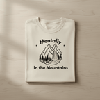 Ivory custom T-shirt with mountain graphic and text "Mentally" and "In the Mountains"