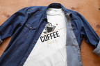 White unisex cotton T-shirt with coffee cup graphic under a blue denim button-up shirt