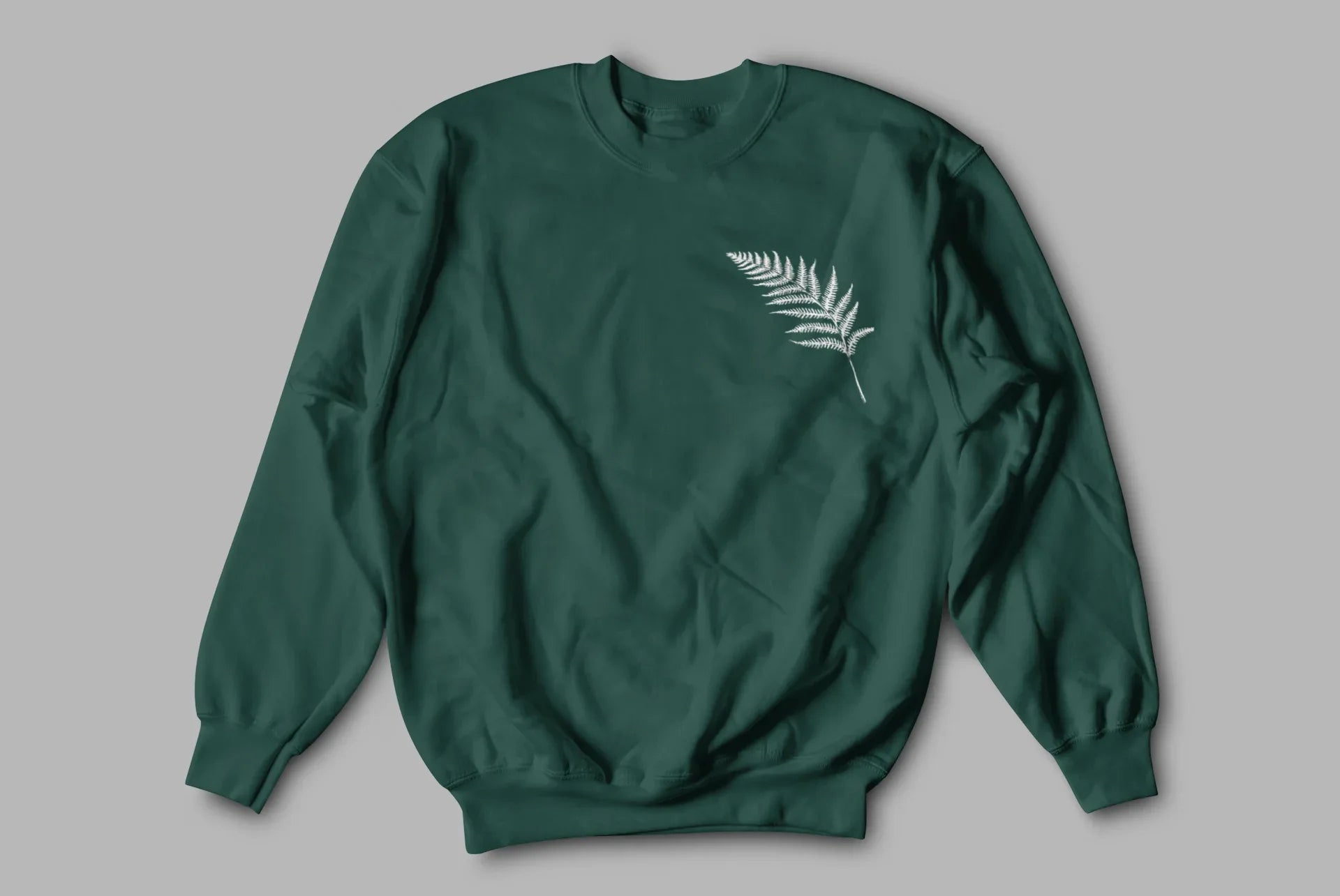 Forest green sweatshirt with a white feathered leaf graphic on the chest.