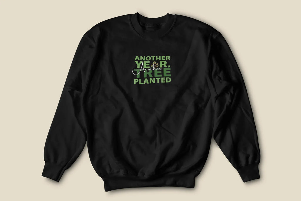 Black crewneck sweatshirt with small green “Another Year, Tree Planted” chest graphic.