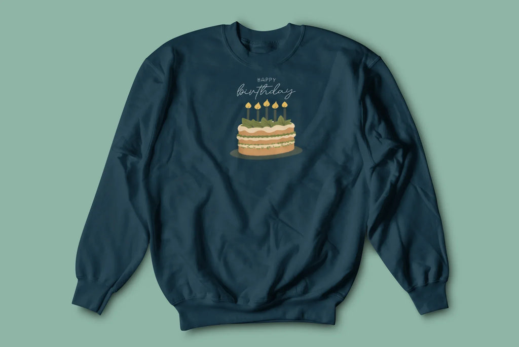 Dark teal crewneck sweatshirt with “Happy birthday” cake and candle graphic