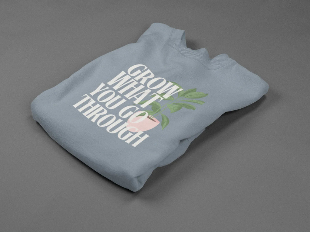 Light blue sweatshirt with “Grow What You Go Through” text and leaf graphic