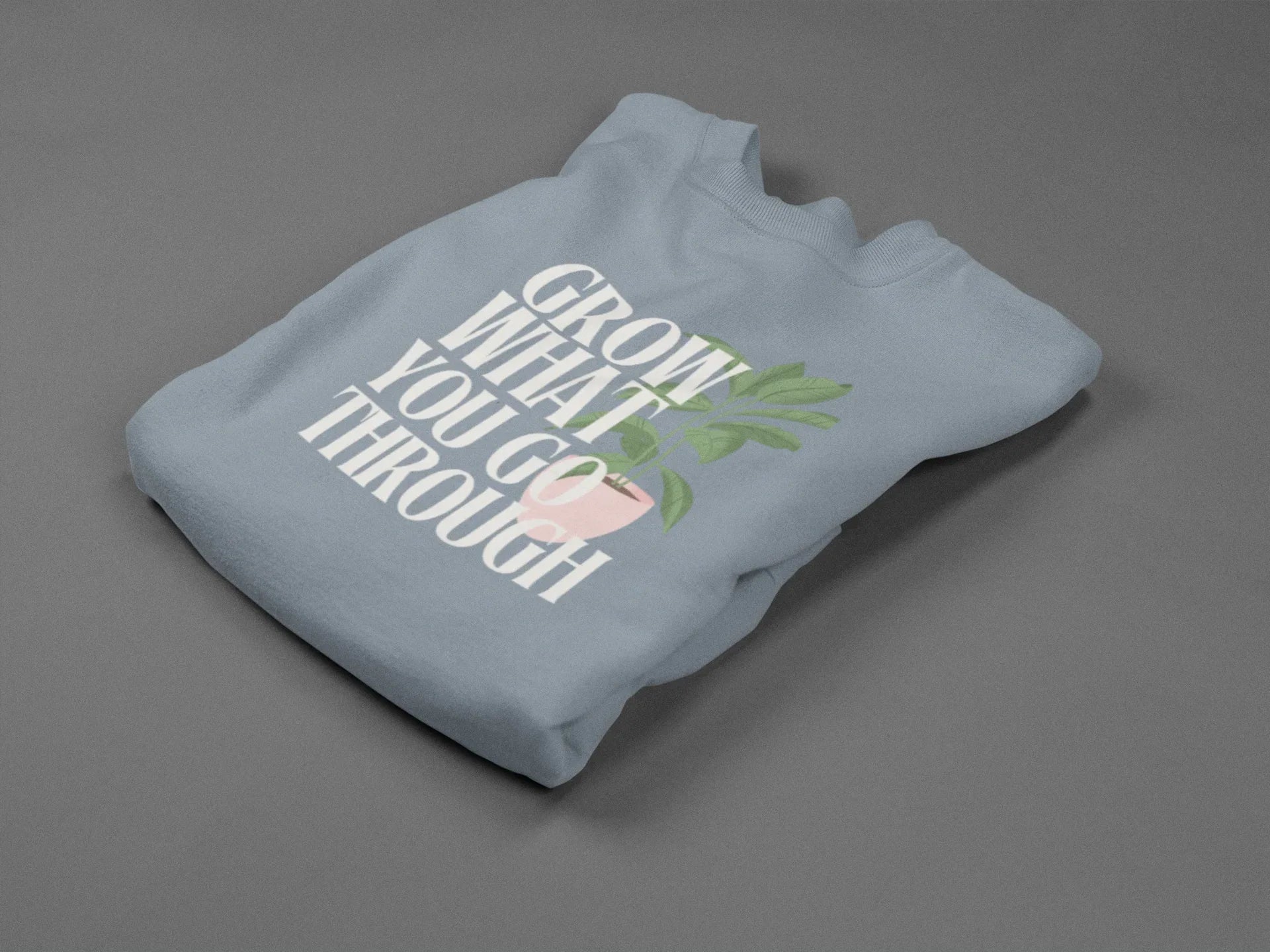 Light blue sweatshirt with “Grow What You Go Through” text and leaf graphic