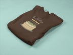 Brown folded sweatshirt with birthday cake and candle print on the chest