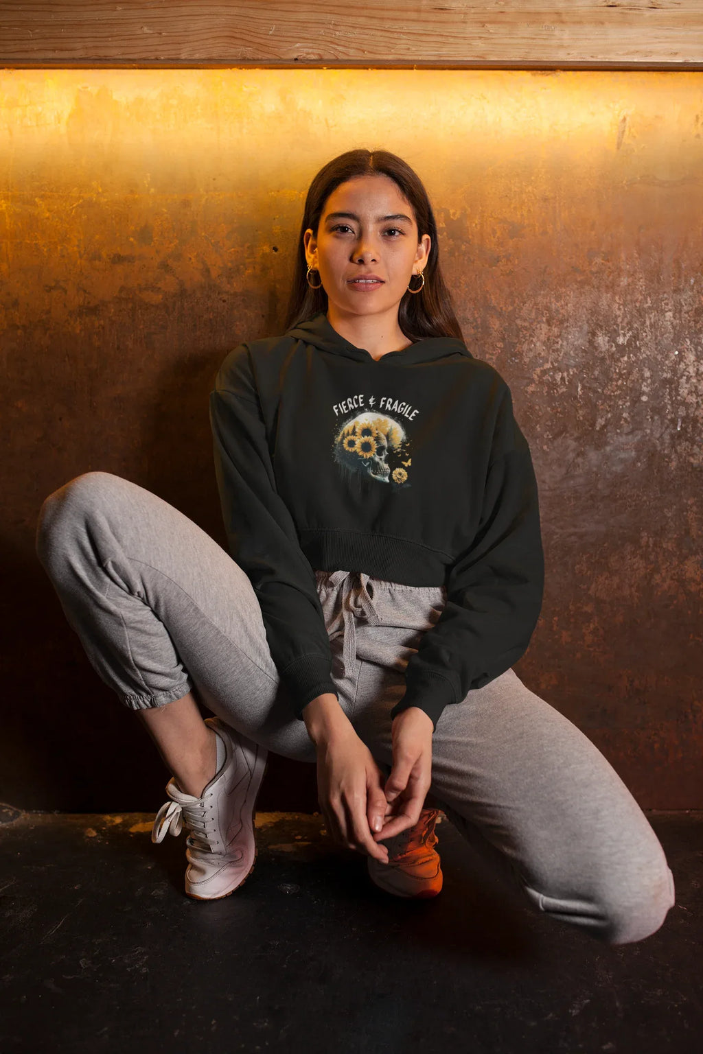 Black hooded sweatshirt with front graphic skull and flower design, long sleeves, pouch pocket and hood.