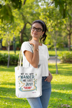 White canvas tote bag with long black handles, worn over shoulder with colorful front print