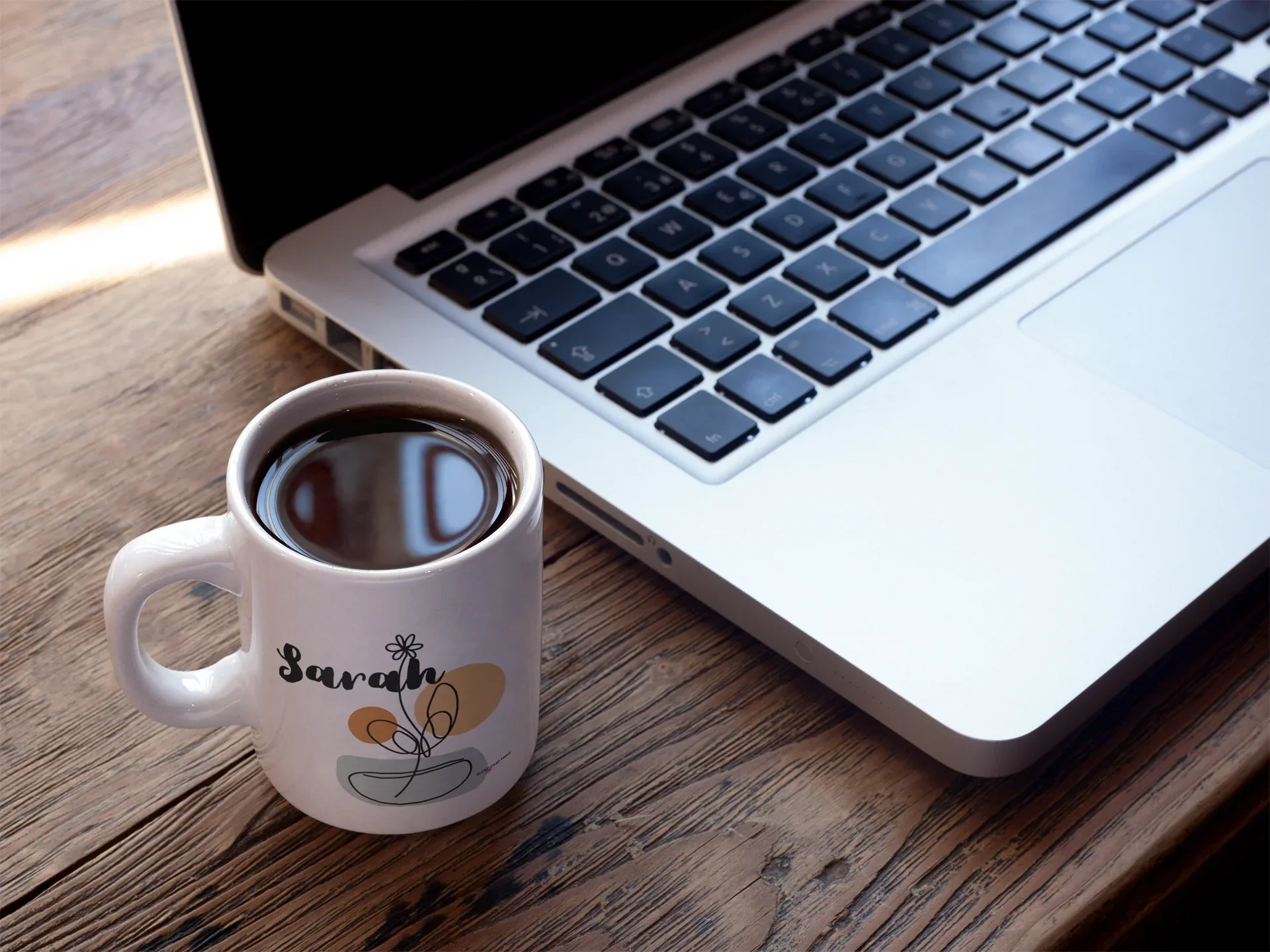 White ceramic mug with Sarah name and floral pot graphic, filled with coffee
