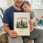 Dad holding a notebook personalised with Lily beside his child