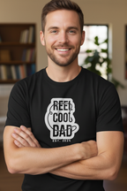 Black crewneck graphic T-shirt with Reel Cool Dad logo and EST. 2024