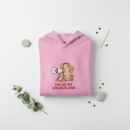 Pink hooded sweatshirt folded flat with woman megaphone graphic and front pocket