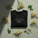 Folded black hoodie with delulu vibes slogan and small heart below