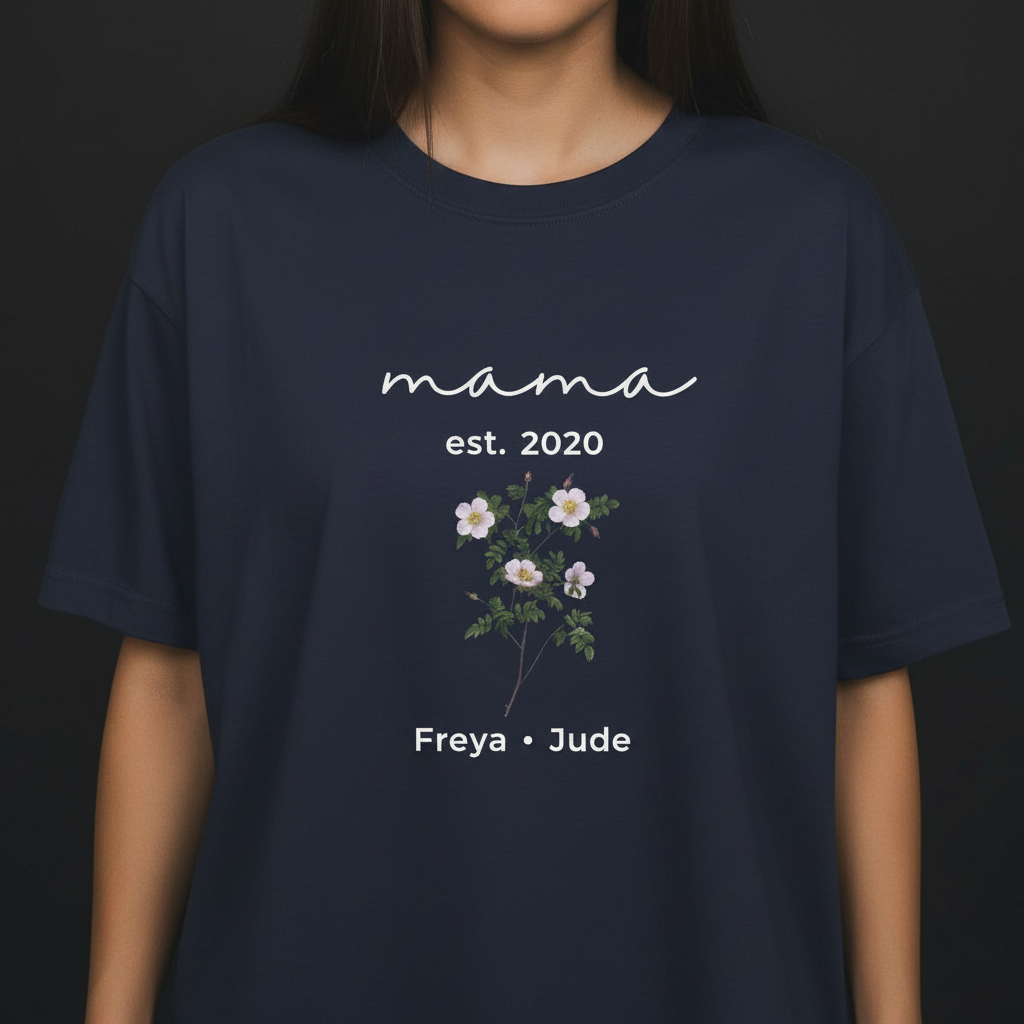 Navy T-shirt with “mama est. 2020,” floral bouquet graphic, and names “Freya • Jude”.