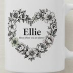 White ceramic mug with floral heart wreath and name Ellie, close-up front print