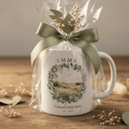 White ceramic coffee mug gift-wrapped with ribbon, countryside wreath and name "EMMA"