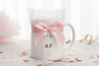 White ceramic engagement mug with pink bow ribbon and "engaged AF" text and hearts