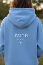 Light blue unisex hoodie with 'FAITH first' chest print and kangaroo pocket
