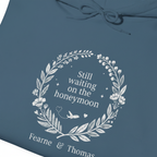 Indigo blue hoodie close-up: white wreath “Still waiting on the honeymoon” print