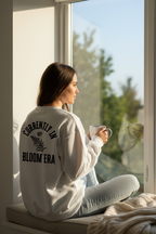 Light gray crewneck sweatshirt with Bloom Era back print and text