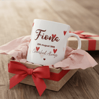 Personalised heart mug, white ceramic with “Fiona” and date in red, hearts