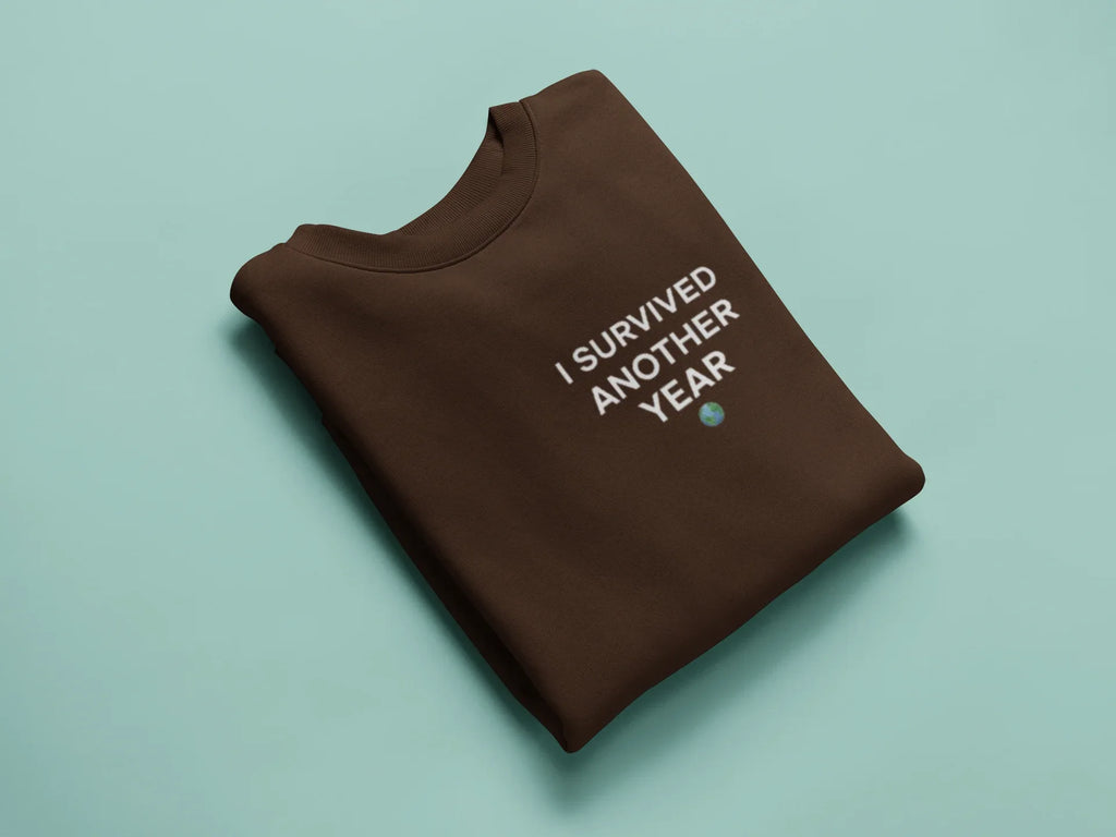 Crewneck sweatshirt in chocolate brown with "I survived another year" graphic