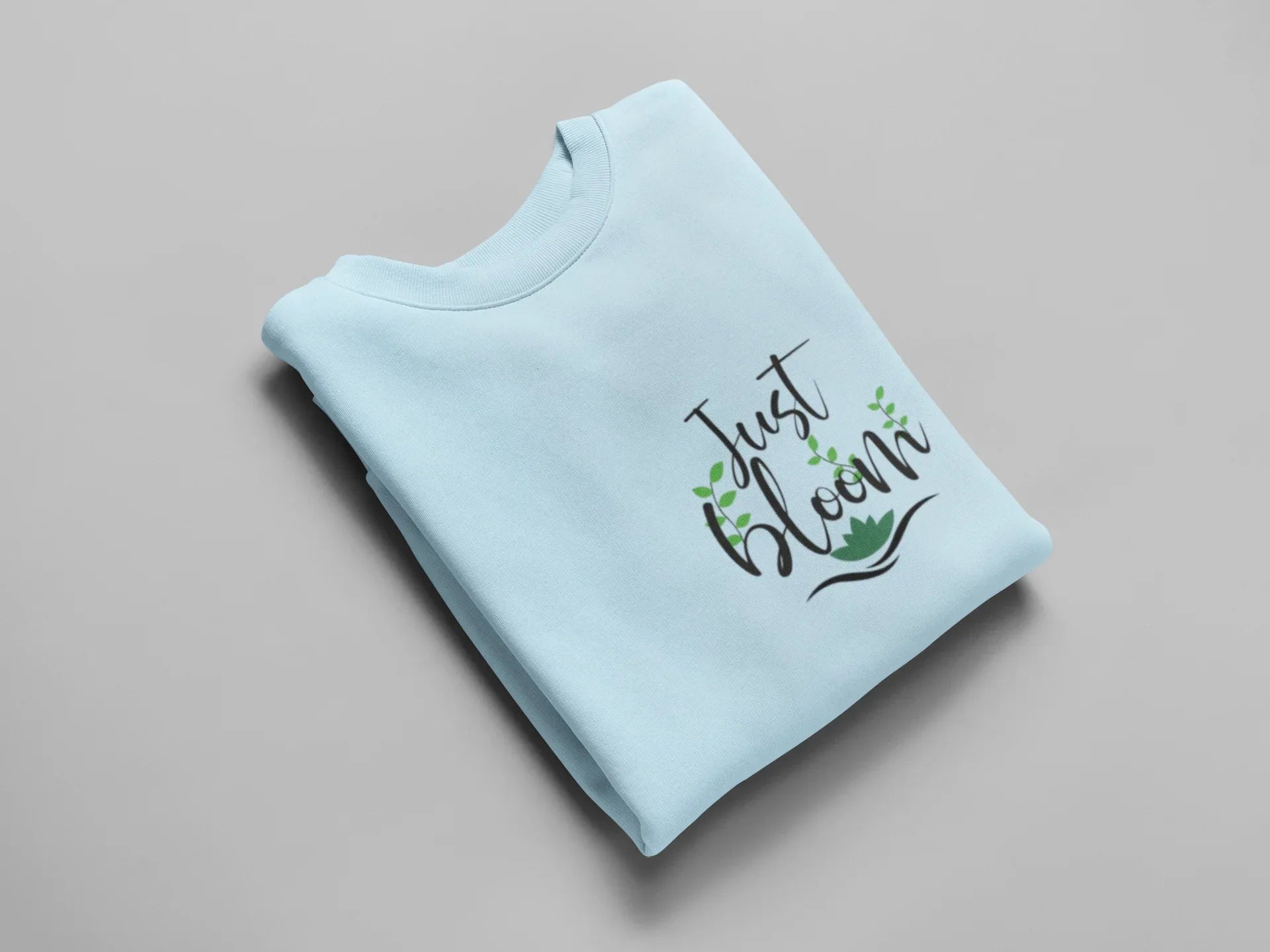 Light blue crewneck sweatshirt with floral “Just Bloom” graphic