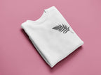 White sweatshirt with a black feathered leaf graphic on the chest.