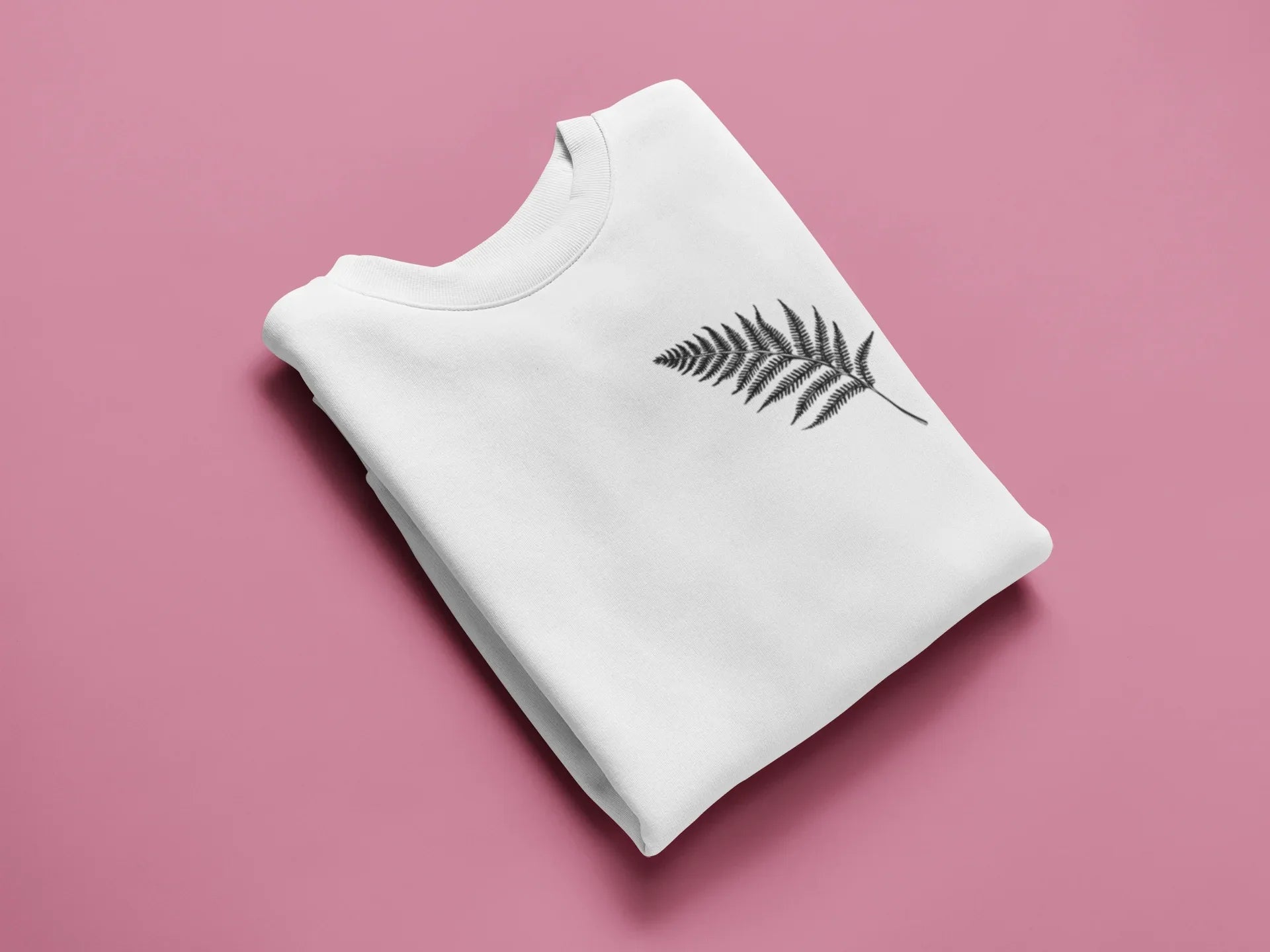 White sweatshirt with a black feathered leaf graphic on the chest.