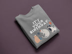 Light gray crewneck cat birthday sweatshirt with front graphic cats and “Your Birthday” text