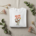 White crewneck sweatshirt with colorful “Take a Deep Breath” floral graphic on chest.
