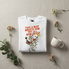 White crewneck sweatshirt with colorful “Take a Deep Breath” floral graphic on front.
