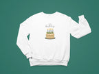 White crewneck sweatshirt with “Happy birthday” cake and candle graphic