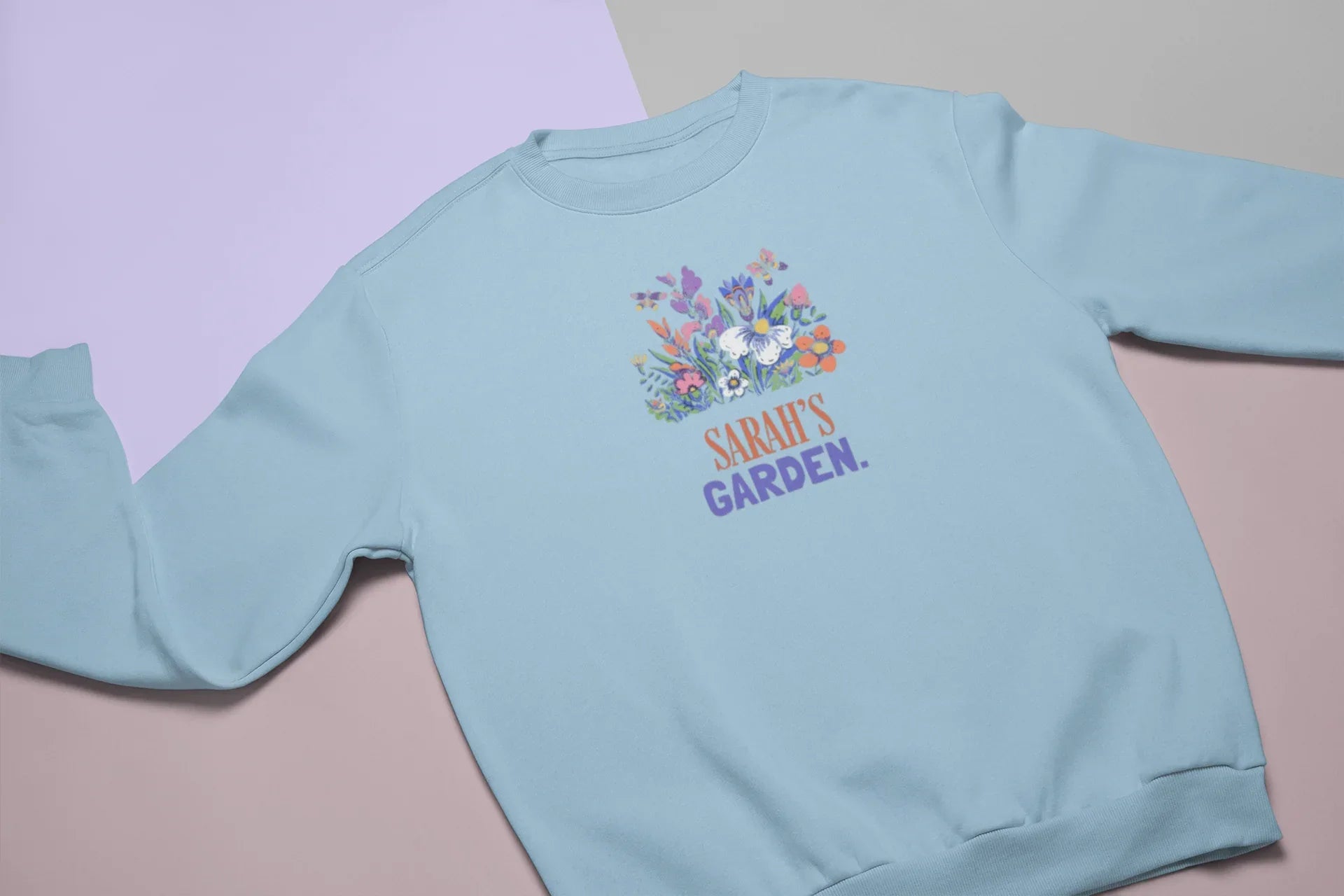Light blue crewneck sweatshirt with floral crest and 'Sarah's Garden' print.