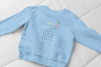 Sky blue kids sweatshirt laid flat with 'I'm Not Tired, You're Tired' character graphic