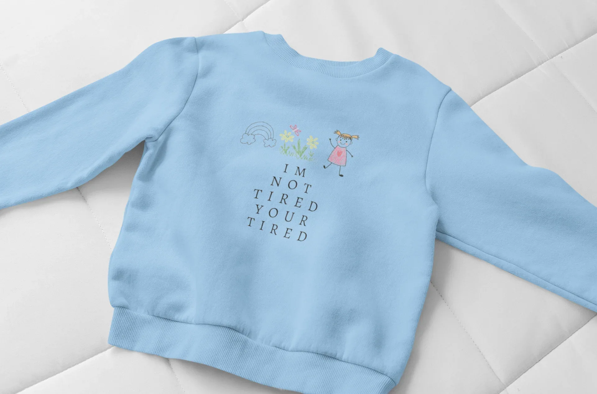 Sky blue kids sweatshirt laid flat with 'I'm Not Tired, You're Tired' character graphic