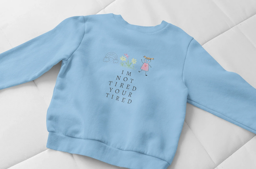 Sky blue kids sweatshirt with 'I'm Not Tired, You're Tired' character graphic