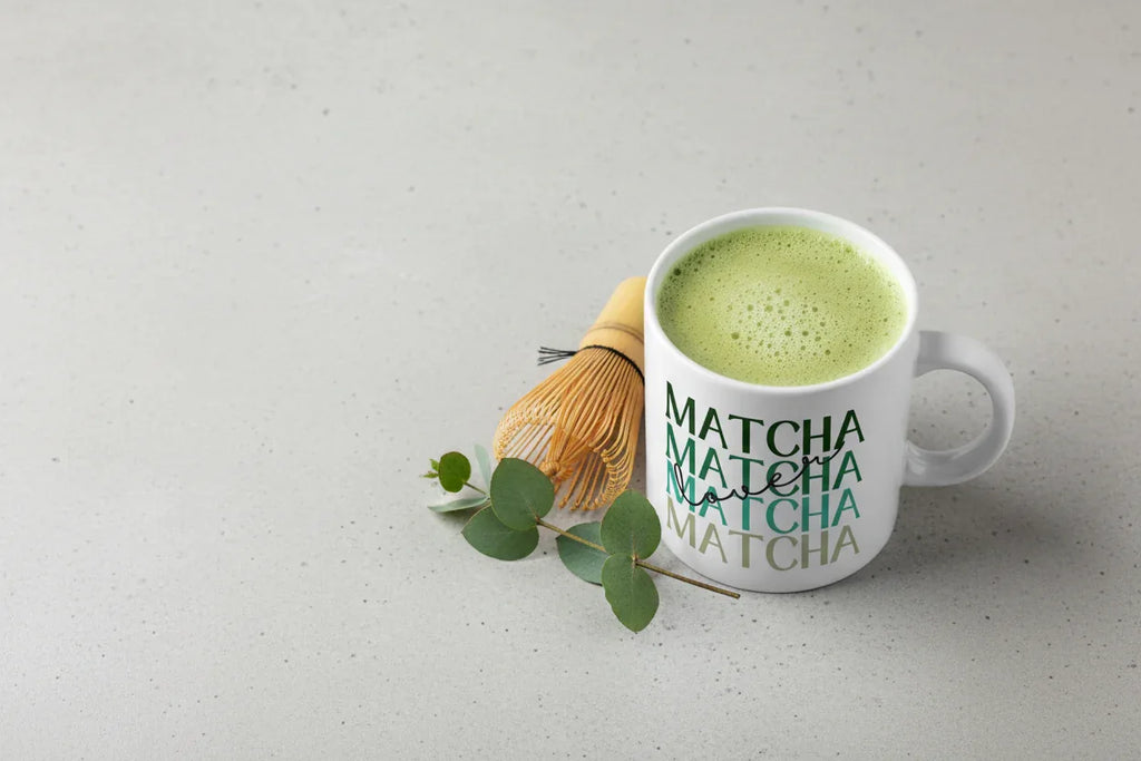 White ceramic matcha mug with green MATCHA text, filled with green tea