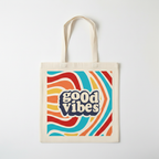 White canvas tote bag front panel showing 'good vibes' retro lettering graphic