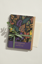 A5 leaf notebook with colorful cover and ribbon bow, displayed on wall