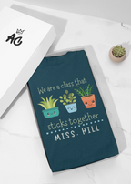 Teal crewneck T-shirt with cartoon plants and 'MISS. HILL' text for teachers.