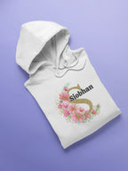 Folded white kids hoodie with floral letter Siobhan graphic and hood