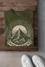 Olive green short-sleeve T-shirt with mountain sunrise “RISE ABOVE” graphic