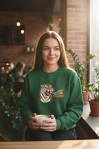 Forest green crewneck sweatshirt with tiger head graphic on the front, woman holding a mug
