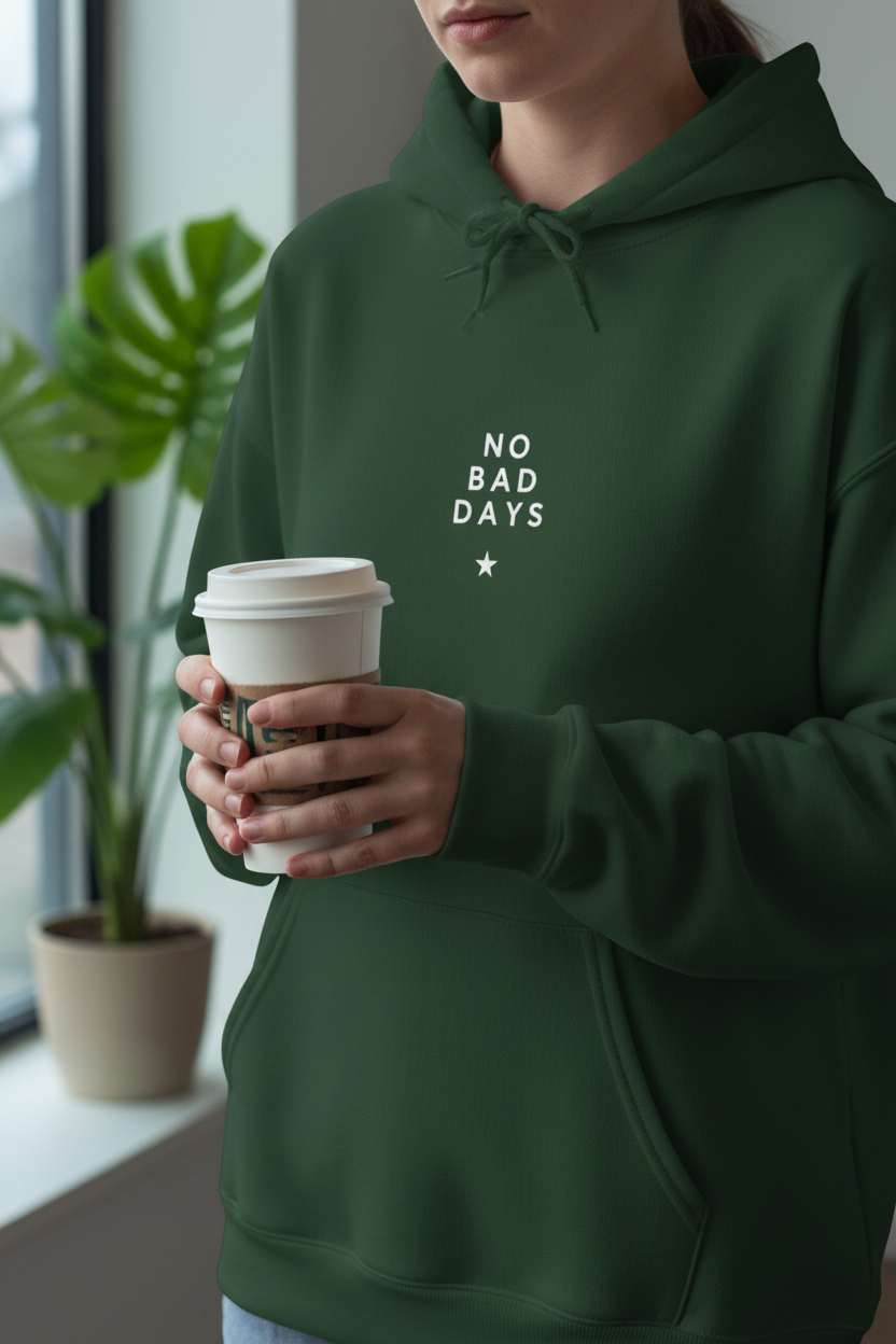 Green hooded sweatshirt on person holding a drink cup; “No Bad Days” chest graphic