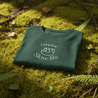 Deep green folded graphic T-shirt with “Slow life” text and cat icon
