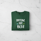 Forest green sweatshirt with 'TRYING MY BEST' quote and globe with leaves graphic