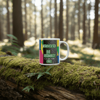 White mug with colorful nature quote resting on a mossy log