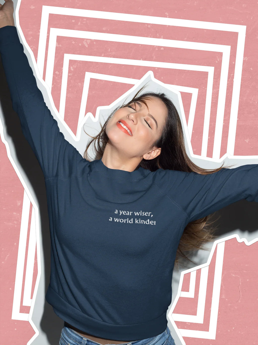 Dark crewneck sweatshirt with chest text: "a year wiser, a world kinder"