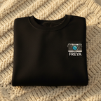 Black sweatshirt with embroidered camera patch and FREYA name