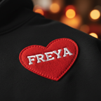 Black hoodie with red heart appliqué patch and 'FREYA' embroidered text